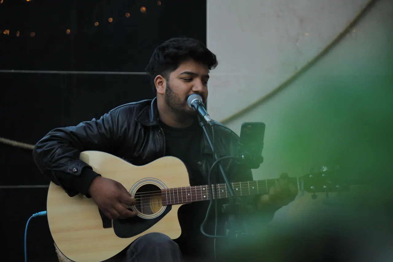 Live music in Manali: a singer with an acoustic guitar and microphone on a night at Bar and Cafe - Do NTHNG